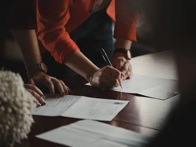 A woman signing a document on a table