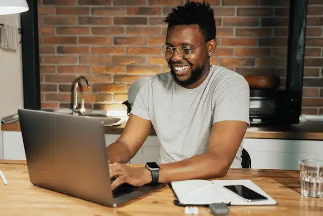 A man sitting at a desk, applying for a title loan online using his laptop, symbolizing the convenience of online title loans in Florida. 